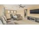 Second living room area with a ceiling fan, multiple seating options and TV at 21610 N Bradford Dr, Maricopa, AZ 85138