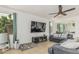 Open-concept living space includes a comfy couch, ceiling fan, and large television at 21610 N Bradford Dr, Maricopa, AZ 85138