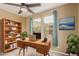 Office area with desk, bookcase, plants, artwork, and natural lighting at 21610 N Bradford Dr, Maricopa, AZ 85138