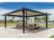 Community picnic shelter with tables and benches, offering a relaxing outdoor space for gatherings and leisure activities at 21610 N Bradford Dr, Maricopa, AZ 85138