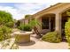 A backyard featuring a stone fire pit, ample greenery, and a covered patio perfect for relaxation and entertaining at 2203 E Tonto Pl, Chandler, AZ 85249