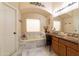 Bathroom featuring a marble-surround bathtub, dual sinks, and decorative accents at 2203 E Tonto Pl, Chandler, AZ 85249