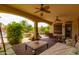 Inviting covered patio with comfortable seating, ceiling fans and a view of the lush backyard creating an outdoor haven at 2203 E Tonto Pl, Chandler, AZ 85249