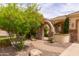 Charming front yard featuring a stone archway, brick pathway, and vibrant, mature landscaping at 2203 E Tonto Pl, Chandler, AZ 85249