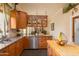 Cozy kitchen featuring stainless dishwasher and sink, granite countertops, and light wood cabinets at 2203 E Tonto Pl, Chandler, AZ 85249