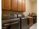 Well-equipped laundry room featuring front loading washer and dryer with ample storage at 2203 E Tonto Pl, Chandler, AZ 85249