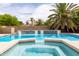 Sparkling pool and spa area with a waterfall feature and lush, mature palm trees at 2203 E Tonto Pl, Chandler, AZ 85249