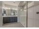 A bathroom with a double sink vanity, large mirror, shower with glass door and tile floors at 22463 E Desert Spoon Dr, Queen Creek, AZ 85142
