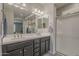 A bathroom with a double sink vanity, large mirror, shower with glass door and tile floors at 22463 E Desert Spoon Dr, Queen Creek, AZ 85142