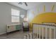 Charming Bedroom with a stylish crib, vibrant wall decor, and cozy seating area at 22463 E Desert Spoon Dr, Queen Creek, AZ 85142