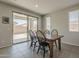 Bright dining area featuring a sliding glass door to the backyard and a wooden table with black chairs at 22463 E Desert Spoon Dr, Queen Creek, AZ 85142
