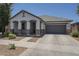 Attractive home with a two-car garage, covered porch, and low maintenance desert landscaping at 22463 E Desert Spoon Dr, Queen Creek, AZ 85142