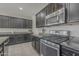 A kitchen showcasing stainless steel appliances, granite countertops, and dark cabinets at 22463 E Desert Spoon Dr, Queen Creek, AZ 85142
