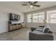 Comfortable living room featuring a large TV, modern entertainment center, and sectional couch at 22463 E Desert Spoon Dr, Queen Creek, AZ 85142