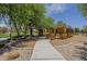 A community playground with shade and various play structures promotes active, outdoor play for of all ages at 22463 E Desert Spoon Dr, Queen Creek, AZ 85142