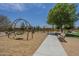 Community playground with swing set and a nearby bench is a tranquil spot for relaxation and play at 22463 E Desert Spoon Dr, Queen Creek, AZ 85142