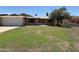 Lovely single-story brick home featuring a lush green lawn and mature trees, offering great curb appeal at 2337 E Manhatton Dr, Tempe, AZ 85282