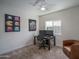 Cozy carpeted bedroom featuring a fan, a desk with computer, and wall decor at 2345 N 28Th Pl, Phoenix, AZ 85008