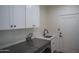 Bright laundry room with white cabinets, modern sink, and stainless steel washer and dryer set at 2345 N 28Th Pl, Phoenix, AZ 85008