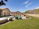A spacious backyard features a lawn, landscaping, and a pool with waterfall features with mountain views at 26409 N 49Th Ln, Phoenix, AZ 85083
