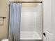 Tiled shower and tub combo with a blue curtain, complemented by neutral walls in a well-lit bathroom at 26409 N 49Th Ln, Phoenix, AZ 85083