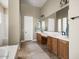 Primary bathroom with double vanity, large mirror, and separate tub and shower at 26409 N 49Th Ln, Phoenix, AZ 85083