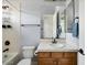 Functional bathroom with a tiled shower and tub, wood vanity, sink, and a large mirror at 26409 N 49Th Ln, Phoenix, AZ 85083