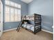 Comfortable bedroom featuring a wooden bunk bed, neutral carpet, blue walls, and a large shuttered window at 26409 N 49Th Ln, Phoenix, AZ 85083