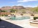 A luxury swimming pool with waterfall features sits on a large patio with mountain views in the background at 26409 N 49Th Ln, Phoenix, AZ 85083