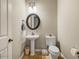 Charming powder room featuring a pedestal sink, round mirror, toilet, and stylish decor for guests at 26409 N 49Th Ln, Phoenix, AZ 85083
