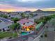 Beautiful aerial view of a home with a pool, lush landscaping, and mountain views at sunset at 27803 N 59Th Dr, Phoenix, AZ 85083