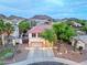 Aerial view of home showcasing a two-car garage, lush trees and desert landscaping at 27803 N 59Th Dr, Phoenix, AZ 85083