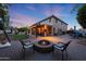 Inviting backyard with brick patio, pergola, fire pit, seating, and well-maintained lawn at 27803 N 59Th Dr, Phoenix, AZ 85083