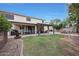Expansive backyard with a covered patio, outdoor dining area, and well-maintained lawn and fire pit at 27803 N 59Th Dr, Phoenix, AZ 85083
