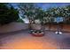 Cozy backyard with a circular brick fire pit, seating and lush greenery at 27803 N 59Th Dr, Phoenix, AZ 85083