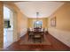 Bright dining room with hardwood floors, neutral walls, wainscoting detail, and a view into the modern kitchen at 27803 N 59Th Dr, Phoenix, AZ 85083