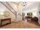 Spacious foyer with staircase, chandeliers, and a glimpse into the inviting living room with hardwood floors at 27803 N 59Th Dr, Phoenix, AZ 85083