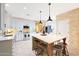 Bright kitchen features white cabinets, stainless appliances, large island with seating, and modern pendant lighting at 27803 N 59Th Dr, Phoenix, AZ 85083