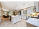 Modern, white kitchen featuring a center island, stainless steel appliances, and an open view to the living area at 27803 N 59Th Dr, Phoenix, AZ 85083