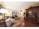 Cozy living room with hardwood floors, a comfortable leather sofa, and natural light from the shuttered windows at 27803 N 59Th Dr, Phoenix, AZ 85083