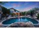 Stunning backyard pool with rock features, mature landscaping, and a relaxing ambiance at 27803 N 59Th Dr, Phoenix, AZ 85083