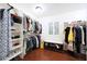 Organized walk-in closet with custom shelving, hardwood floors, and a window at 27803 N 59Th Dr, Phoenix, AZ 85083