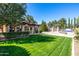 Expansive backyard with lush green lawn and meticulous landscaping, leading to the pool at 29 E Oakwood Hills Dr, Chandler, AZ 85248
