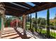 Inviting balcony with a wooden pergola, stone columns, and views of the landscaped grounds at 29 E Oakwood Hills Dr, Chandler, AZ 85248