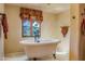 Well-lit bathroom with a classic clawfoot bathtub and decorative window treatment at 29 E Oakwood Hills Dr, Chandler, AZ 85248