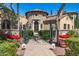 Elegant gated entrance with a brick pathway and vibrant red potted flowers at 29 E Oakwood Hills Dr, Chandler, AZ 85248