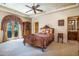Well-appointed main bedroom with ornate bed, ceiling fan, and access to ensuite bath at 29 E Oakwood Hills Dr, Chandler, AZ 85248