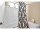 Close up of white tile shower/tub combo with light blue patterned curtain at 2959 W Eastman Dr, Anthem, AZ 85086