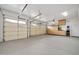 Spacious three-car garage with ample storage, epoxy floor, and bright lighting, suitable for vehicles and projects at 2959 W Eastman Dr, Anthem, AZ 85086
