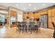 Eat-in kitchen with stainless appliances, wood cabinets, tile backsplash, and seating at the island at 2959 W Eastman Dr, Anthem, AZ 85086